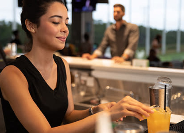 Bartender serving drinks at a bar.